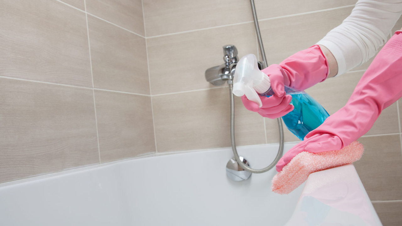 ピンクのゴム手袋をしてお風呂掃除